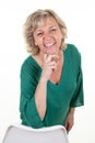 Senior blonde woman smiling happy hand finger over chin pretty cute aged 60 elderly isolated white background laughing Royalty Free Stock Photo