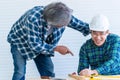 Senior builder bragging and helping a younger worker in home improvement project