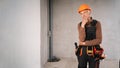 Senior builder on construction site standing wearing safety helmet thinking an idea while looking away. Elderly building worker Royalty Free Stock Photo