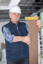 Senior builder measures angle wood