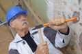 Senior builder using hammer and chisel