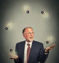 Senior business man executive in suit juggling playing with light bulbs