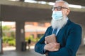 Senior business man holding digital tablet while wearing face mask during corona virus Royalty Free Stock Photo