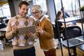 Senior business woman and her young colleague standing in office with digital tablet Royalty Free Stock Photo