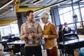 Senior business woman and her young colleague standing in office with digital tablet Royalty Free Stock Photo