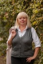 Senior business woman walking in the autumn Park. A woman in a classic clothing style. Elegant woman in a costume. Business woman. Royalty Free Stock Photo