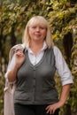 Senior business woman walking in the autumn Park. A woman in a classic clothing style. Elegant woman in a costume. Business woman Royalty Free Stock Photo