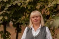 Senior business woman walking in the autumn Park. A woman in a classic clothing style. Elegant woman in a costume. Business woman. Royalty Free Stock Photo