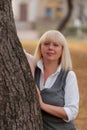 Senior business woman walking in the autumn Park. A woman in a classic clothing style. Elegant woman in a costume. Business woman. Royalty Free Stock Photo