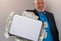 Senior businessman with briefcase full of dollars