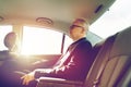 Senior businessman driving on car back seat