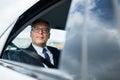 Senior businessman driving on car back seat