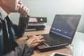 Senior Businessman in grey suit thinking and using laptop at his Royalty Free Stock Photo