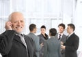 Senior businessman on phone in office lobby Royalty Free Stock Photo