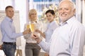 Senior businessman raising champagne glass