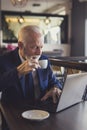 Senior businessman reading news on laptop computer Royalty Free Stock Photo