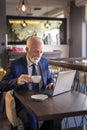 Senior businessman reading news on laptop computer Royalty Free Stock Photo