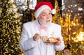 Senior businessman in santa claus hat. Christmas sweets and treats. Christmas decor. Gingerbread concept. Dieting. Cafe