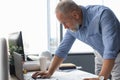 Senior businessman with a stylish short beard working on laptop computer at his office desk Royalty Free Stock Photo