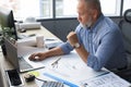 Senior businessman with a stylish short beard working on laptop computer at his office desk Royalty Free Stock Photo