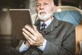 Senior businessman using digital tablet. Focus on hand. Royalty Free Stock Photo