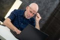 Senior businessman using laptop, he is having difficulties and vision problems Royalty Free Stock Photo