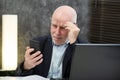 Senior businessman using smartphone, he is having difficulties and vision problems Royalty Free Stock Photo