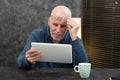 Senior businessman using tablet, he is having difficulties and vision problems
