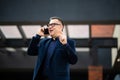 Senior businessman walking and having a conversation at phone. Portrait of mature confident smiling man wearing elegant suit Royalty Free Stock Photo