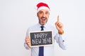 Senior businessman wearing christmas hat holding blackboard over isolated white background surprised with an idea or question Royalty Free Stock Photo