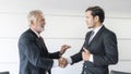 Senior businessman and young businessman partner are happy and shake hand about his great business deal Royalty Free Stock Photo