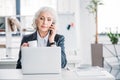 Senior businesswoman holding coffee cup and talking on smartphone Royalty Free Stock Photo