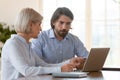 Senior businesswoman millennial businessman using laptop working together in office Royalty Free Stock Photo