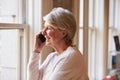 Senior Businesswoman On Mobile Phone In Office