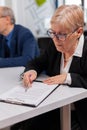 Senior businesswoman reading paperwork in conference room