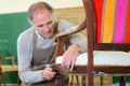 Senior cabinetmaker repairs chair