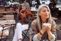 Senior cafe guests, focus on silver haired woman with glasses recording audio message