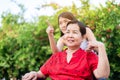 Senior care insurance concept,Caregiver take care to elderly asian woman sitting on wheelchair at outdoor
