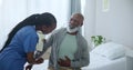 Senior care, nurse and black man with pain in stomach for advice, healthcare and exam on bed. Homecare, abdomen and