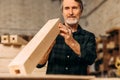 Senior carpenter checking a block of wood Royalty Free Stock Photo