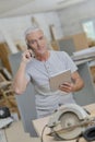 senior carpenter embracing technology Royalty Free Stock Photo