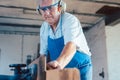 Senior carpenter working with wood planer on workpiece Royalty Free Stock Photo