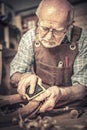 Senior carpenter sanding chair