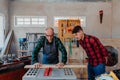 Senior carpenter teaching a younger man how to work Royalty Free Stock Photo