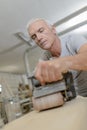 Senior carpenter using belt sander Royalty Free Stock Photo