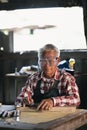 Senior carpenter working on woodworking machines in carpentry shop. man works in a carpentry shop. Royalty Free Stock Photo