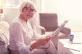 Smiling positive senior woman carrying fresh newspaper