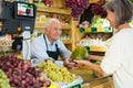 Senior cashier serving customer in greengrocer Royalty Free Stock Photo