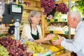 Senior cashier woman serving customer in greengrocer Royalty Free Stock Photo