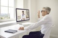 Senior Caucasian businessman sitting in the office talking to his doctor by video link. Royalty Free Stock Photo